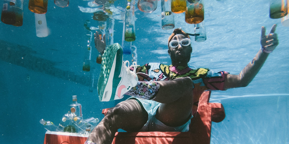 man partying underwater in pool with drinks